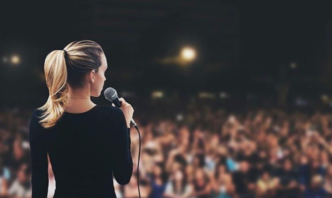 A speaker with a microphone facing the audience